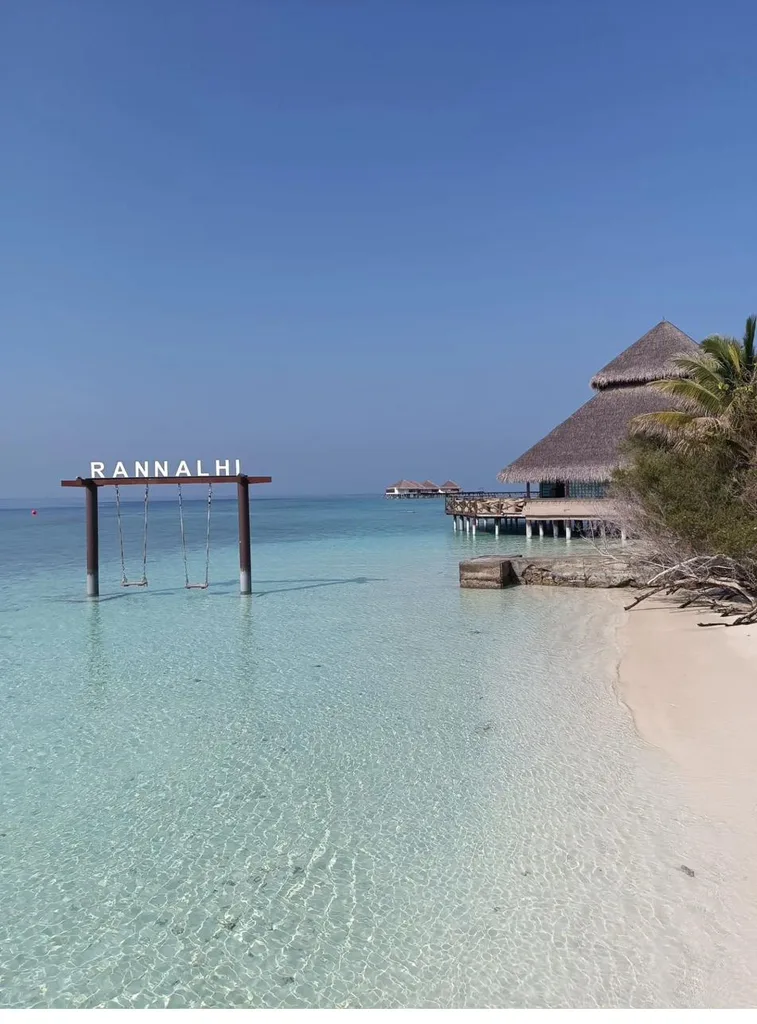 Thatched overwater pavilion at the end of a jetty with a beach swing in the lagoon