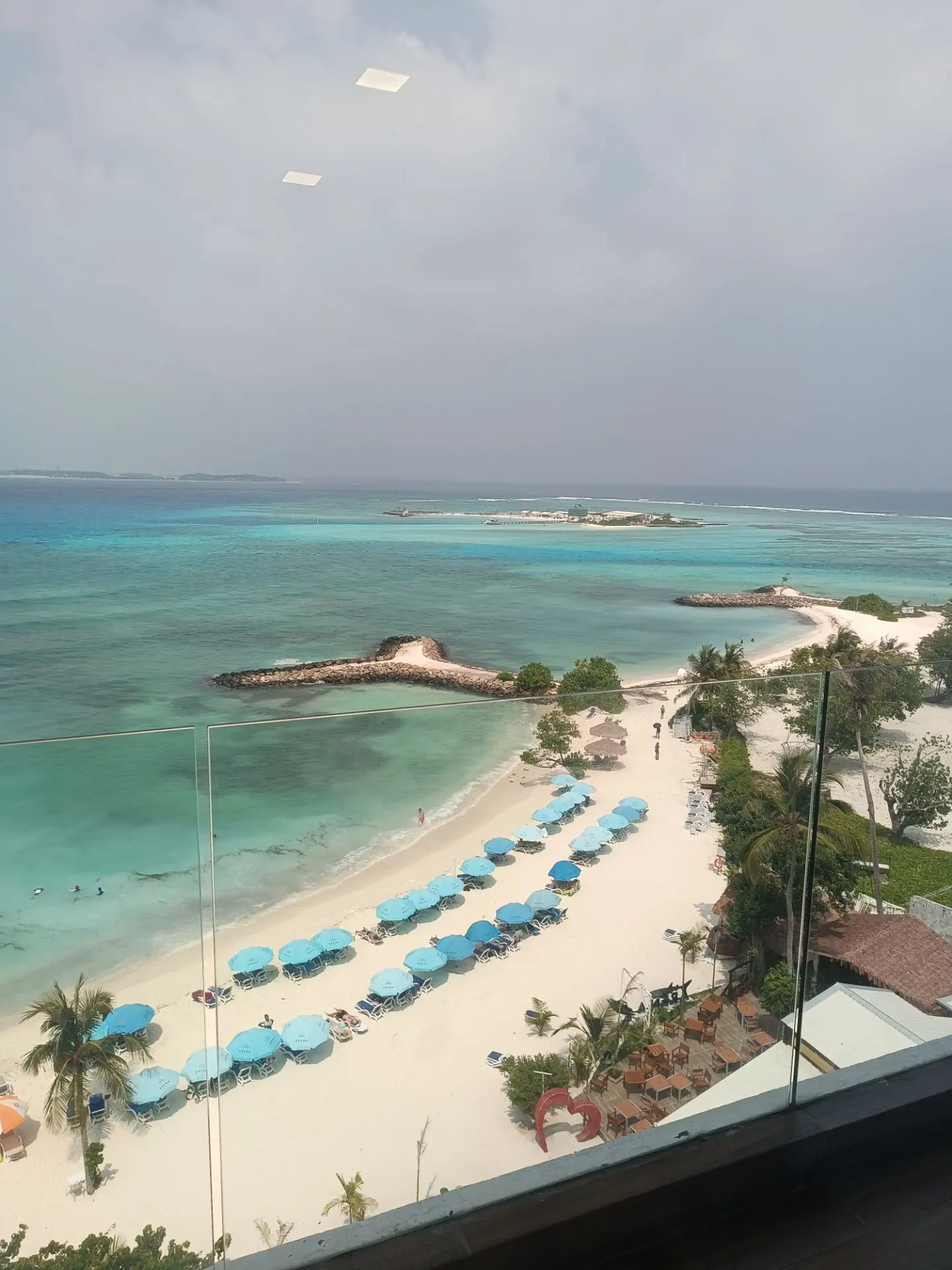 What Changes When You Cross the Waterline: Resort Island vs Local Island in the Maldives 12 Rows of umbrellas and sunbeds along the designated bikini beach on a Maldives local island