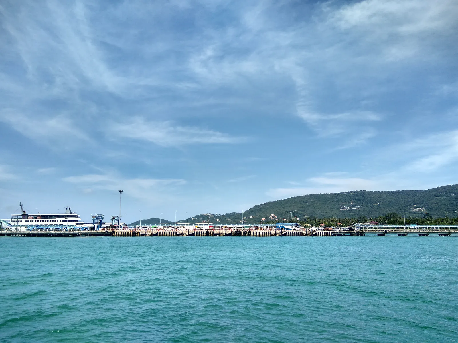 Pier with a passenger ferry and boats at a Thai island harbour